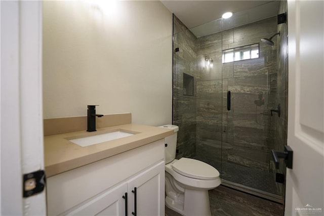 bathroom with vanity, toilet, and a shower with shower door