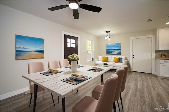 dining space with ceiling fan and wood-type flooring