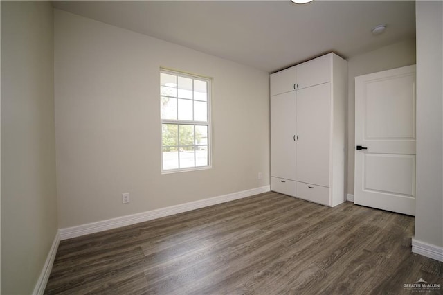 unfurnished bedroom with dark wood-type flooring