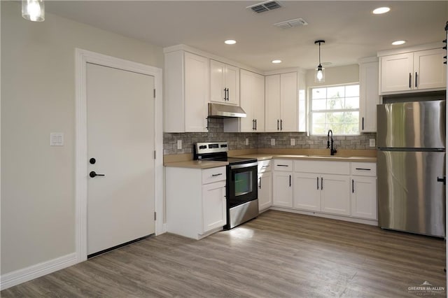 kitchen with pendant lighting, sink, white cabinetry, and stainless steel appliances