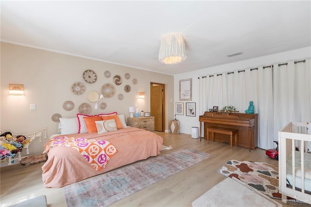 1011 W Orange St, Mcallen, TX 78501 - bedroom featuring wood finished floors, a chandelier, and crown molding