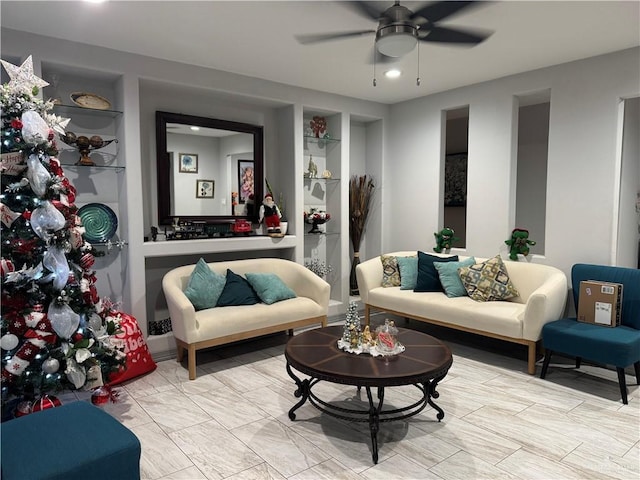 living room with built in features and ceiling fan