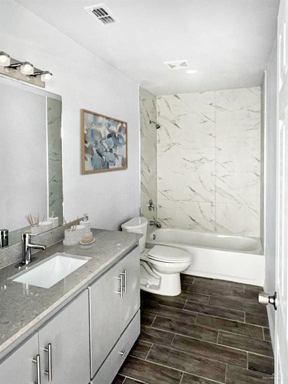 full bathroom featuring vanity, toilet, and tiled shower / bath combo