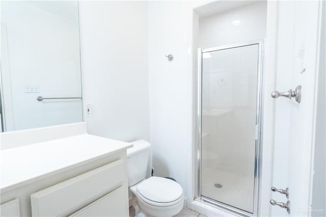 bathroom featuring toilet, a shower with shower door, and vanity