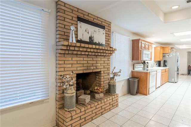 living room with a brick fireplace and light tile patterned floors