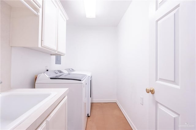 washroom featuring washing machine and dryer, cabinets, and sink