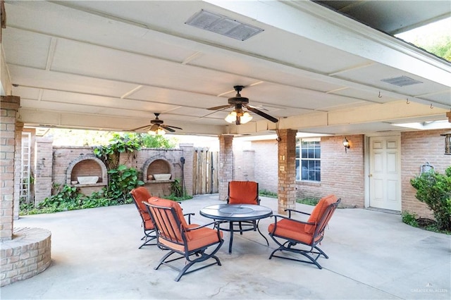 view of patio featuring ceiling fan and an outdoor brick fireplace