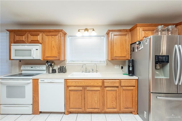 kitchen with sink, white appliances, and light tile patterned flooring