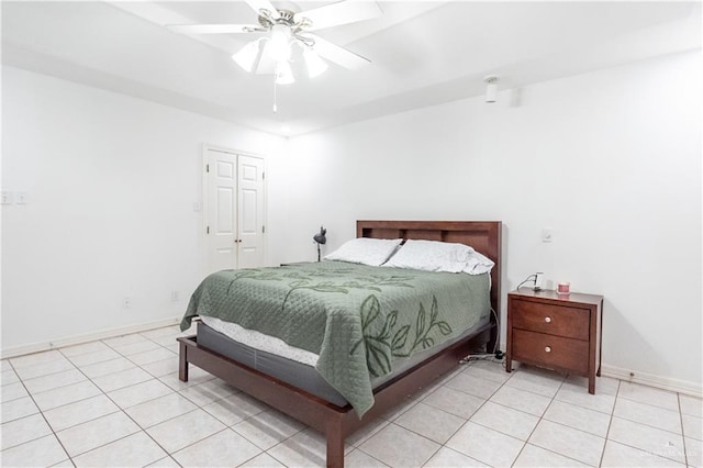 bedroom with ceiling fan, light tile patterned floors, and a closet