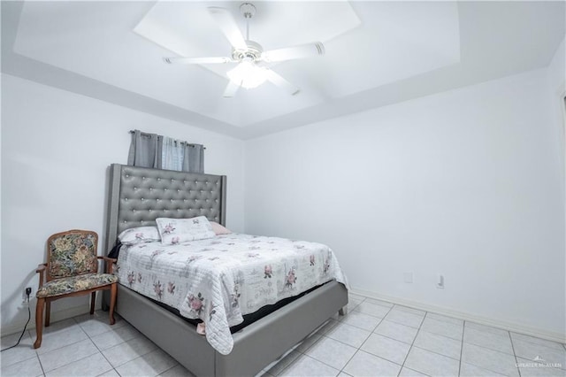 bedroom featuring ceiling fan, light tile patterned floors, and a raised ceiling