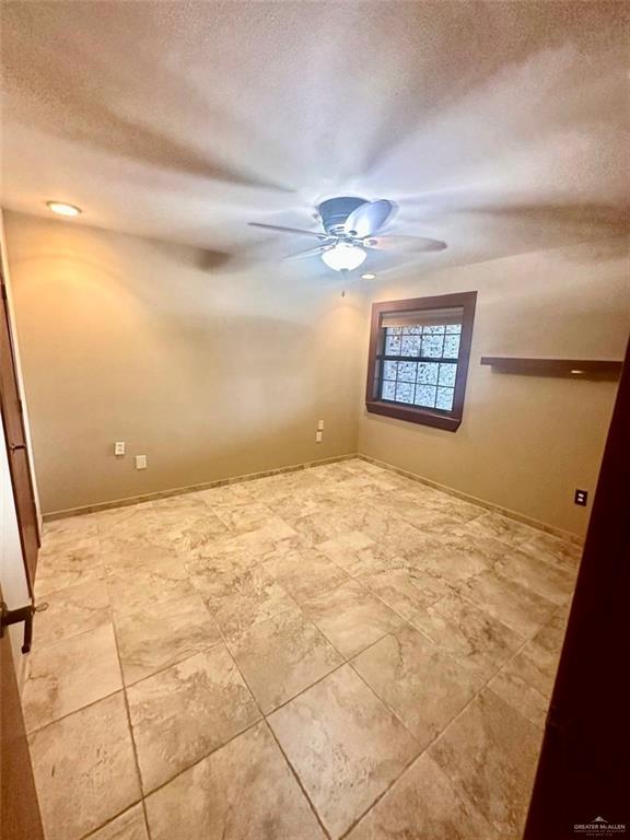 unfurnished room featuring a textured ceiling and ceiling fan