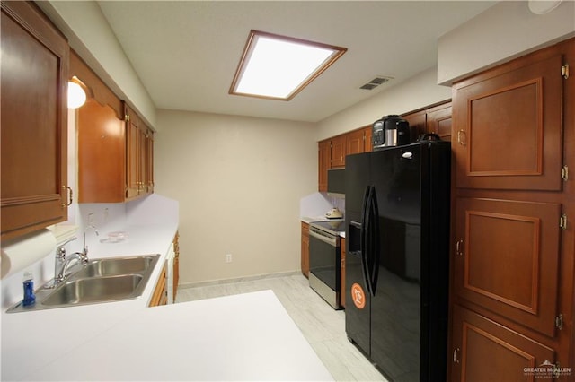 kitchen with black fridge with ice dispenser, stainless steel range with electric cooktop, and sink