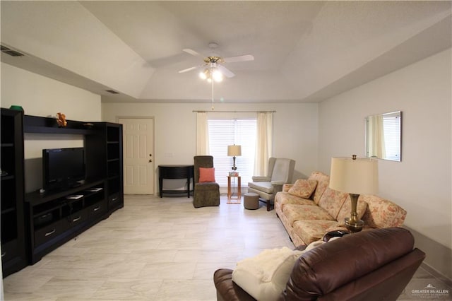 living room with a tray ceiling and ceiling fan