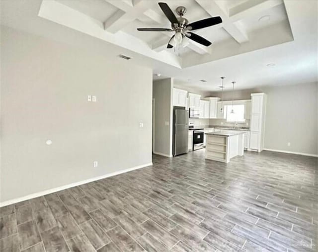 1009 W La Pointe Ave, Mission, TX 78573 - unfurnished living room with coffered ceiling, wood finish floors, baseboards, ceiling fan, and beam ceiling