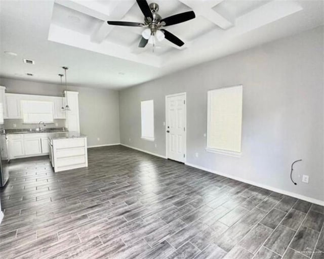 1009 W La Pointe Ave, Mission, TX 78573 - unfurnished living room with coffered ceiling, dark wood-style floors, baseboards, a ceiling fan, and beam ceiling