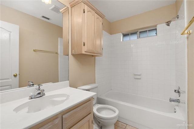 full bathroom featuring tile patterned floors, vanity, tiled shower / bath combo, and toilet