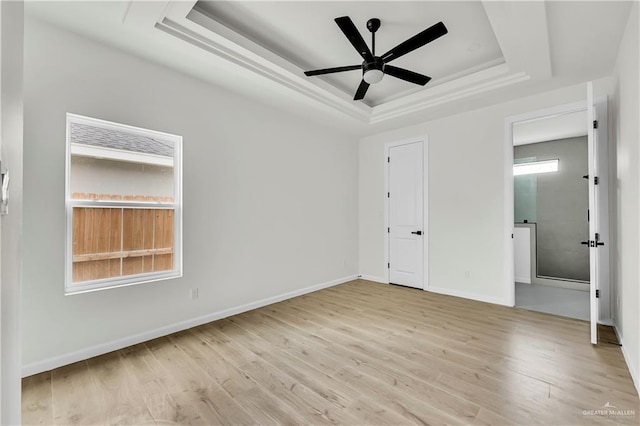 unfurnished bedroom featuring a raised ceiling, light wood-type flooring, and ceiling fan