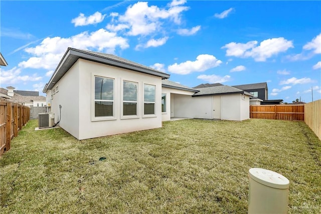 back of property featuring a yard and central AC unit