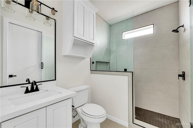 bathroom with vanity, tile patterned flooring, toilet, and tiled shower