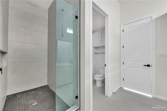 bathroom featuring toilet and a shower with door