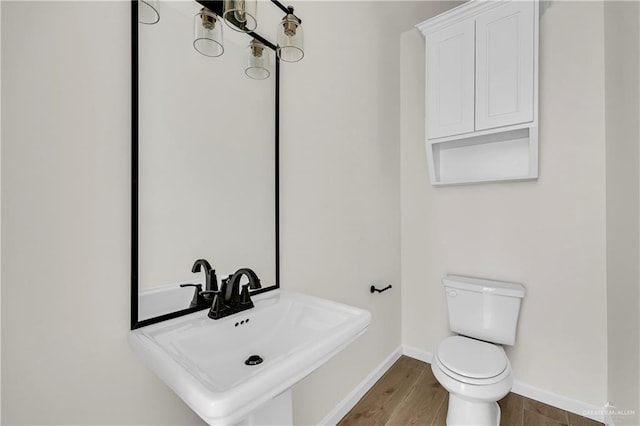 bathroom with sink, hardwood / wood-style floors, and toilet