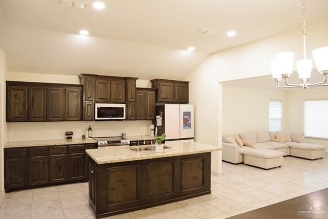 kitchen featuring dark brown cabinetry, lofted ceiling, decorative light fixtures, and white appliances