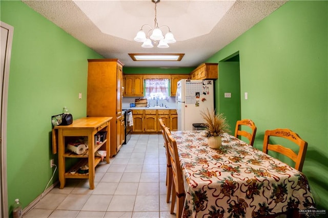 dining space with light tile patterned flooring, an inviting chandelier, and a textured ceiling