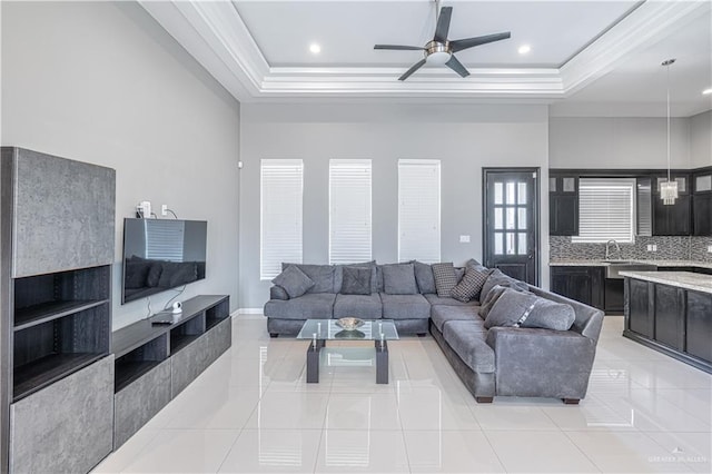 3527 Oak Preserve St, Weslaco, TX 78599 - living room with ornamental molding, a ceiling fan, light tile patterned flooring, and a raised ceiling