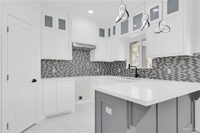 kitchen featuring white cabinetry, pendant lighting, sink, and exhaust hood