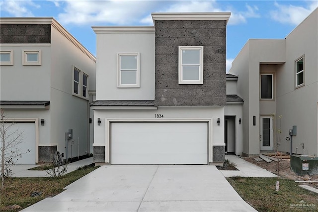 view of front of property featuring a garage and central AC unit