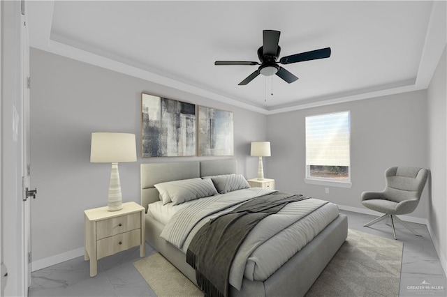 bedroom with ceiling fan and a tray ceiling