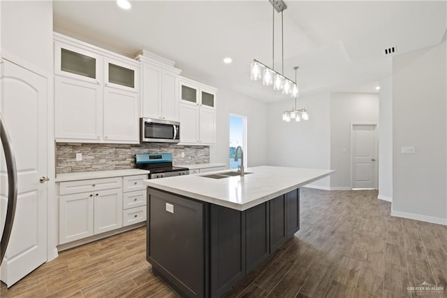 2214 N Gaytan St, Edinburg, TX 78542 - kitchen with stainless steel appliances, a sink, backsplash, a center island with sink, and light countertops