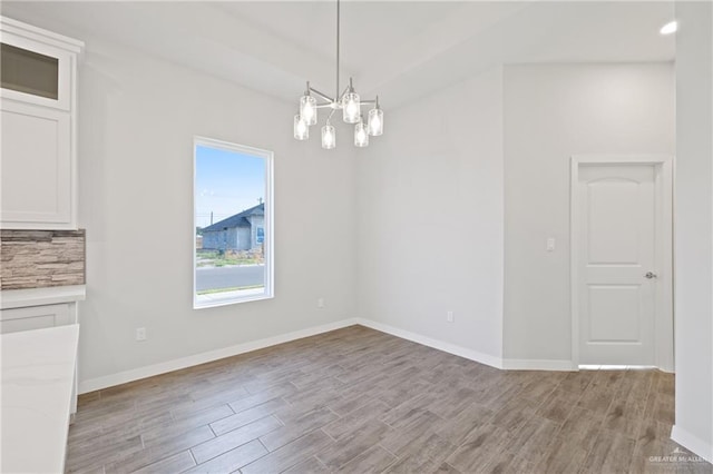 2214 N Gaytan St, Edinburg, TX 78542 - unfurnished dining area with light wood-style flooring, baseboards, and a chandelier