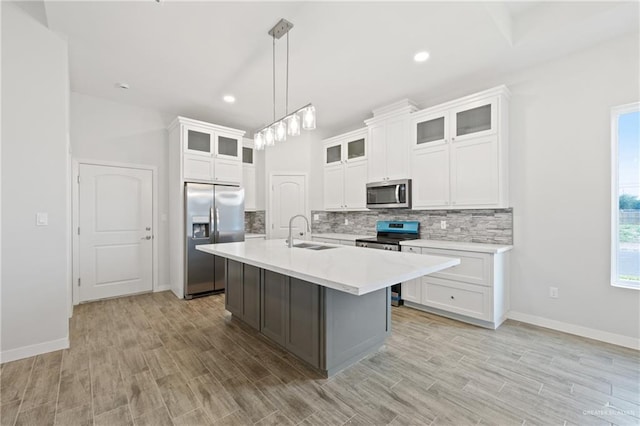 2214 N Gaytan St, Edinburg, TX 78542 - kitchen with stainless steel appliances, a sink, backsplash, light countertops, and a kitchen island with sink