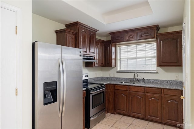 1610 E Yary Dr, Edinburg, TX 78542 - kitchen featuring stainless steel appliances, a tray ceiling, a sink, light tile patterned flooring, and under cabinet range hood