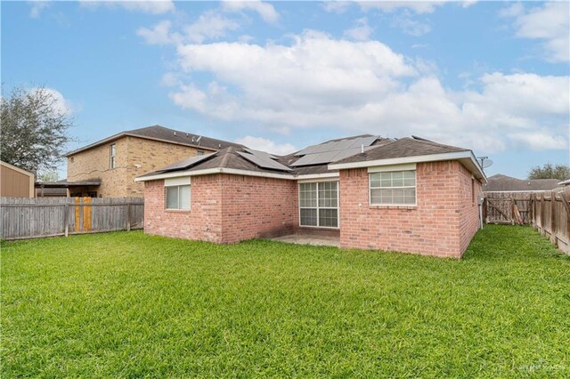 1610 E Yary Dr, Edinburg, TX 78542 - back of property featuring a fenced backyard, roof mounted solar panels, and brick siding