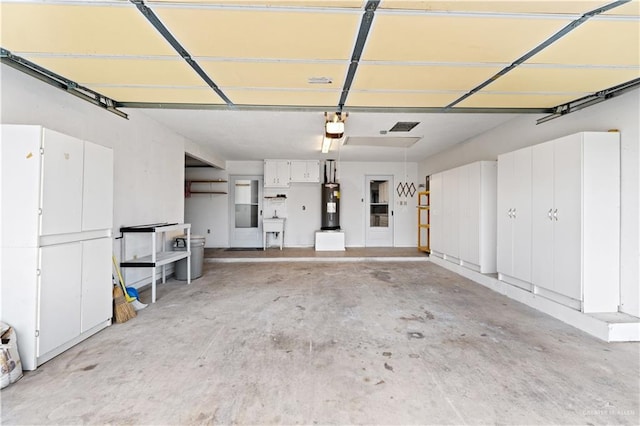 garage featuring sink, a garage door opener, and water heater