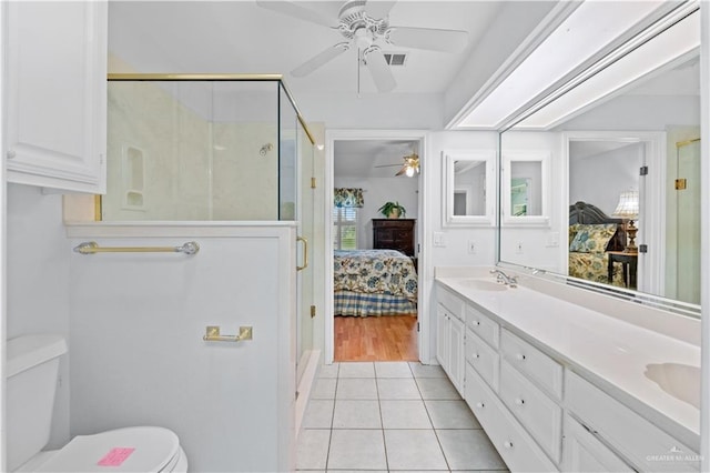 bathroom featuring tile patterned floors, vanity, toilet, and an enclosed shower