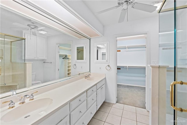 bathroom with ceiling fan, walk in shower, tile patterned floors, toilet, and vanity