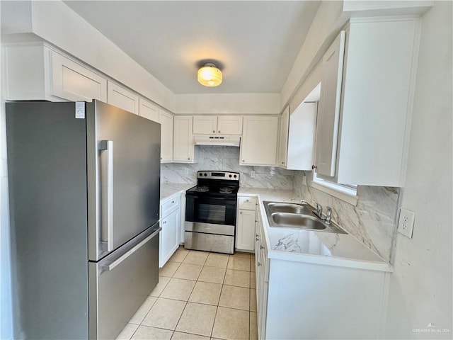 kitchen with sink, stainless steel appliances, white cabinets, decorative backsplash, and light tile patterned flooring