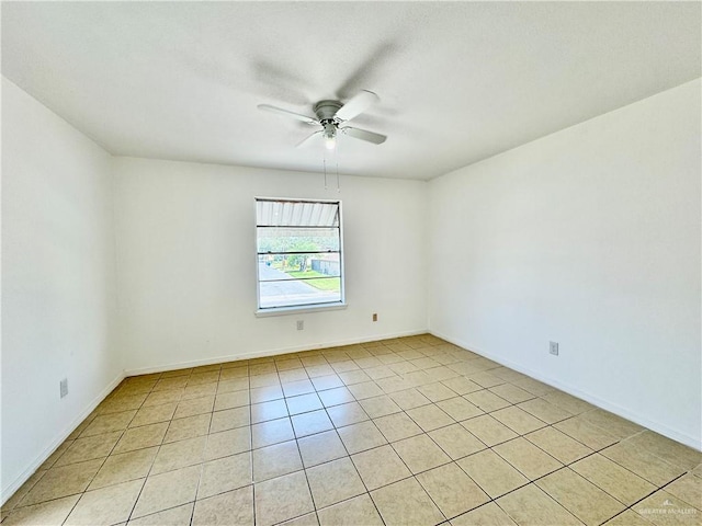 tiled spare room featuring ceiling fan