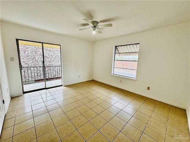 empty room with ceiling fan and light tile patterned floors