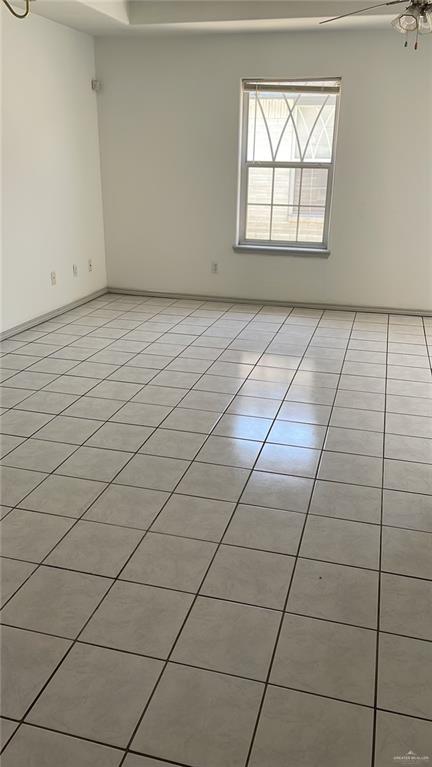 empty room with ceiling fan and light tile patterned flooring