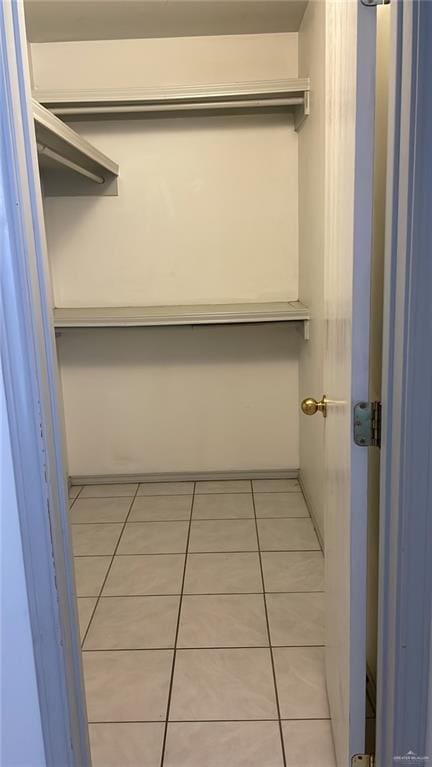 walk in closet with light tile patterned floors