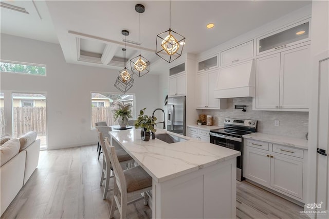 kitchen featuring plenty of natural light, tasteful backsplash, coffered ceiling, custom exhaust hood, and stainless steel appliances