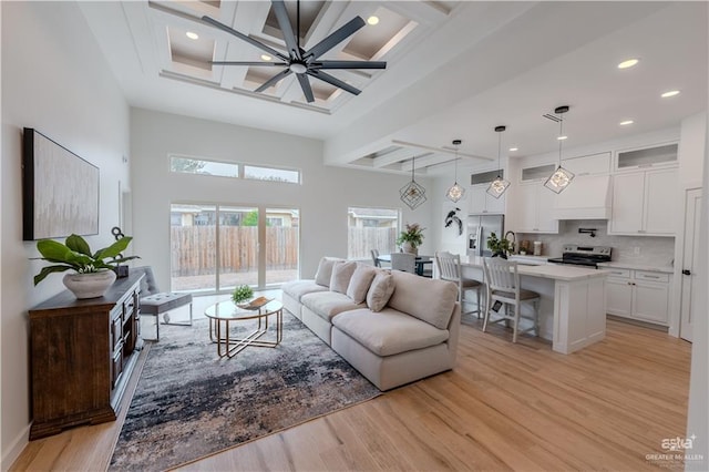 living room with light wood finished floors, coffered ceiling, ceiling fan, beam ceiling, and recessed lighting