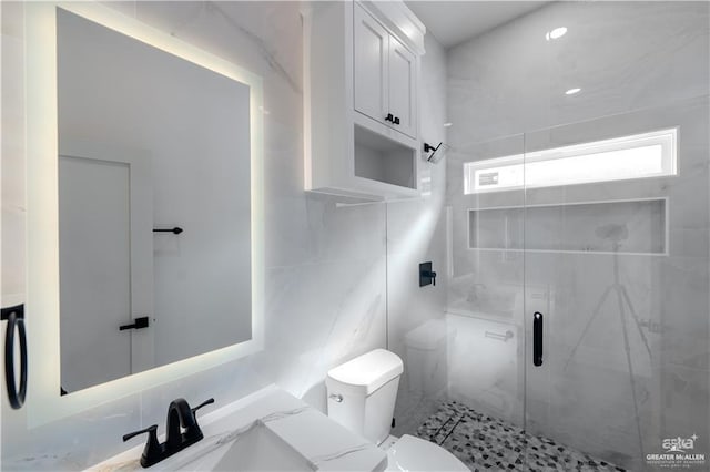 bathroom featuring toilet, a shower stall, and vanity