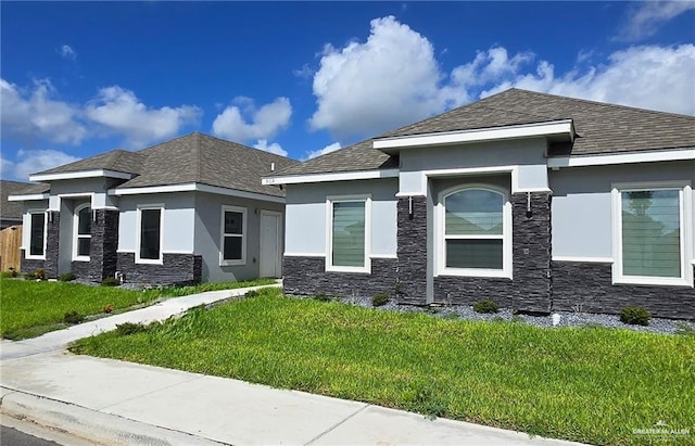 prairie-style home featuring stone siding, stucco siding, and a front yard