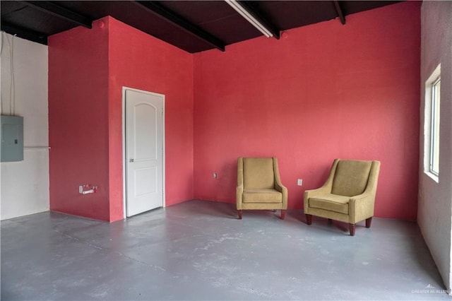 unfurnished room featuring electric panel and beam ceiling