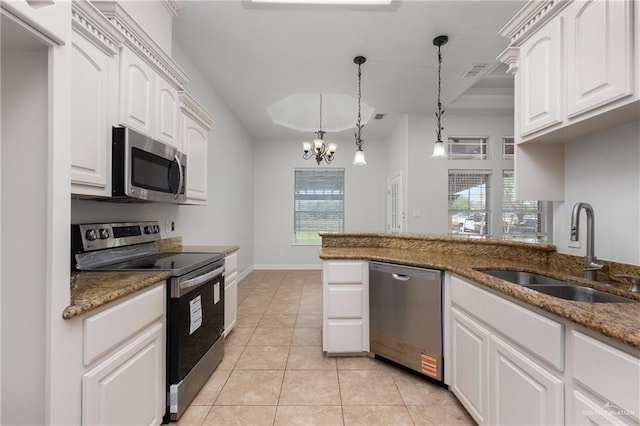 4113 Ulex Ave, Mcallen, TX 78504 - kitchen featuring appliances with stainless steel finishes, a sink, dark stone countertops, pendant lighting, and white cabinetry